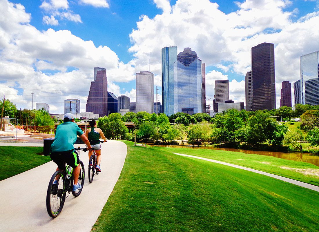 Employee Benefits - Couple Riding Their Bikes Through a Park in Houston, Texas